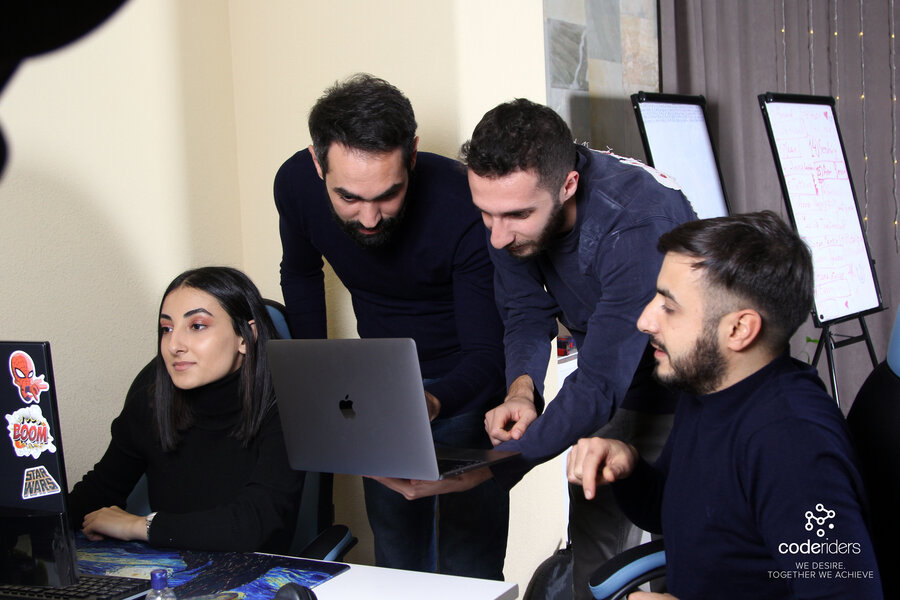CodeRiders software developer Shant with his colleagues discussing their software outsourcing project CodeRiders software developers and designers including senior software engineer Shant working on a complex software development project